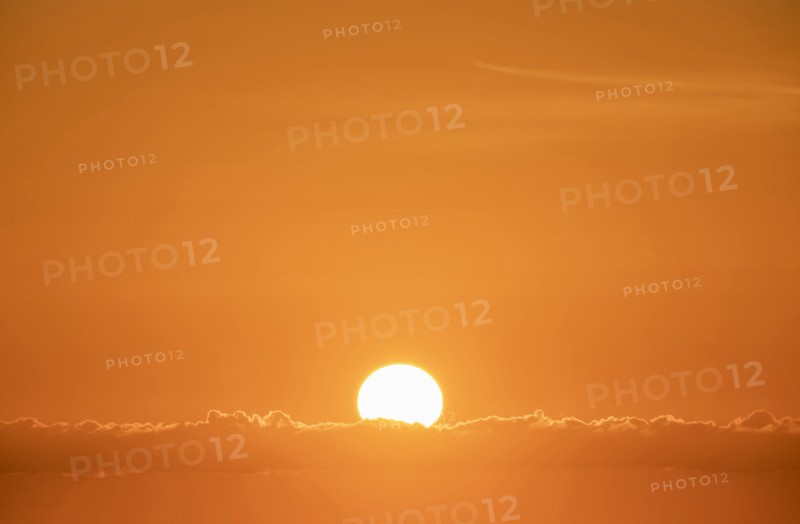 Sun rising in orange sky