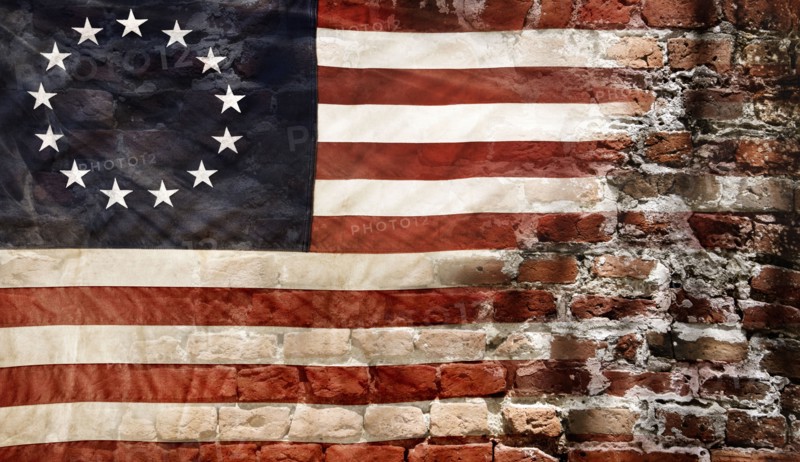 Betsy Ross flag with 13 stars on brick wall