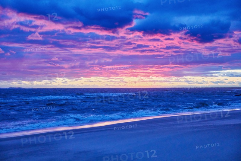 Beach and sea at sunset with dramatic blue and purple sky