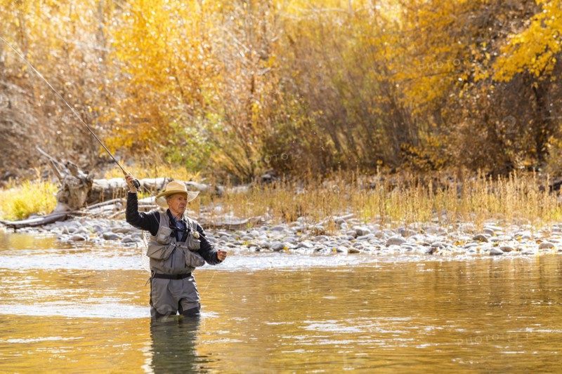 Senior man fly fishing in Big Wood River in Autumn