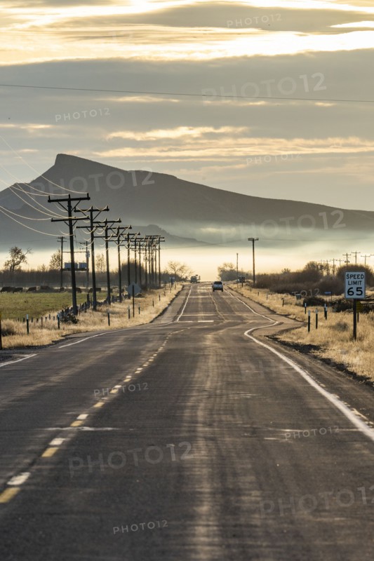 Rural road with mountain and morning mist in distance