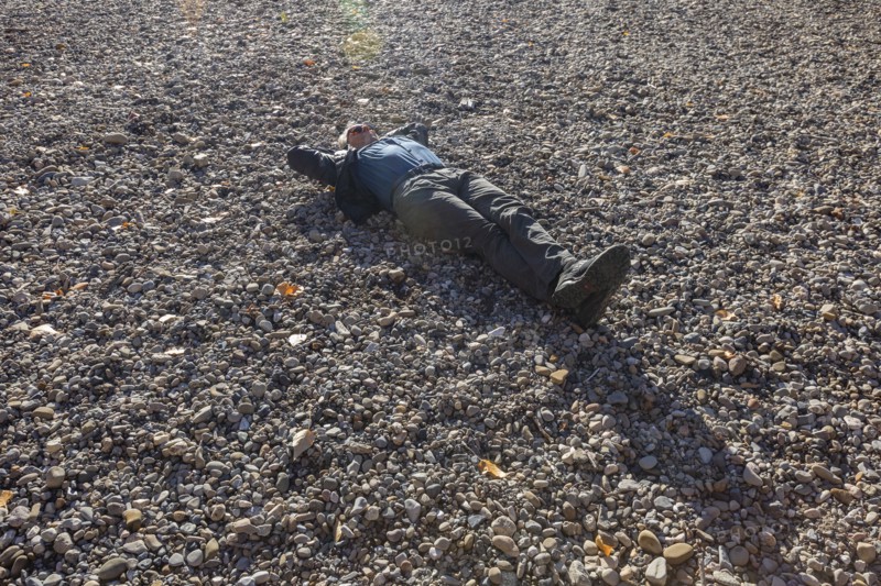 Senior man relaxing of empty river bottom