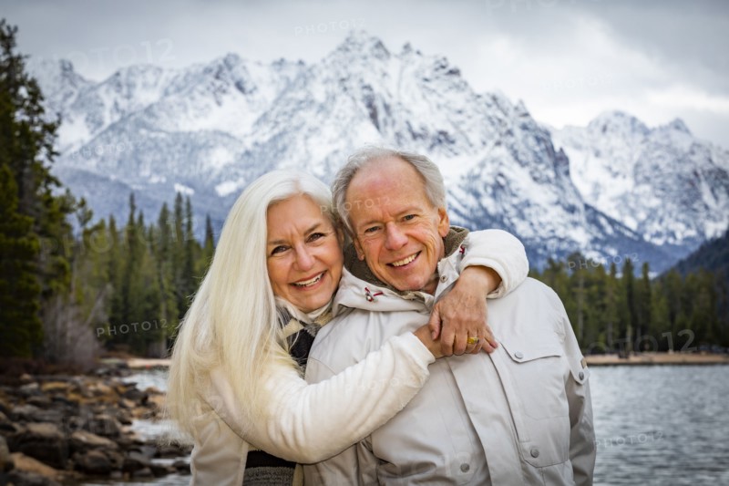 Portrait of smiling senior couple at mountain lake