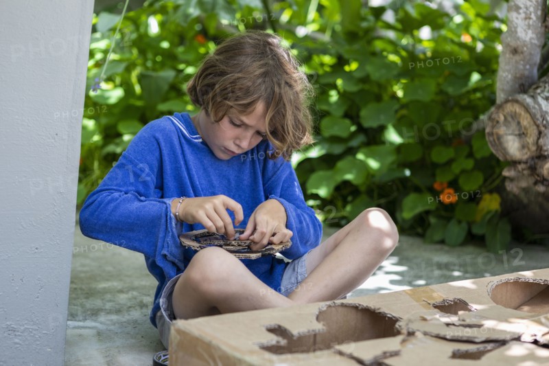 Boy cutting a cardboard box