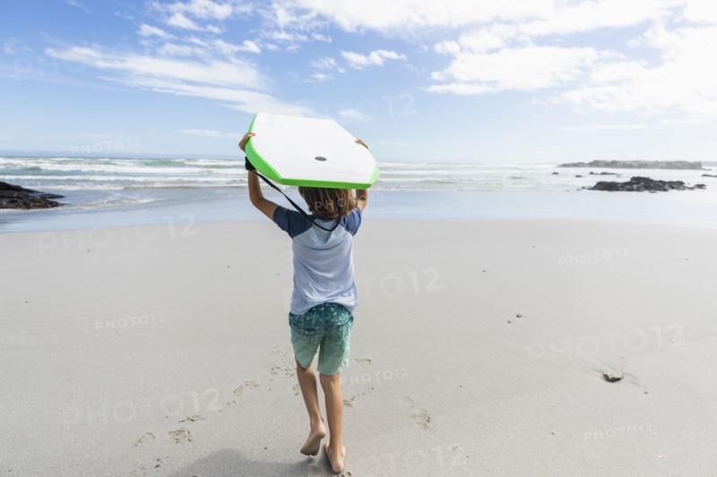 Boy with surfboard on beach