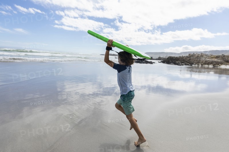 Boy with surfboard on beach