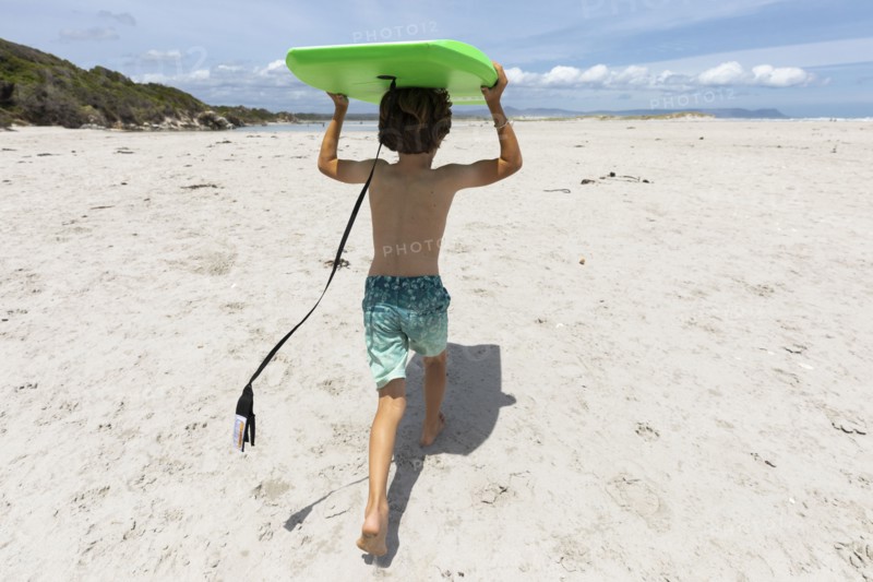 Boy with surfboard on beach