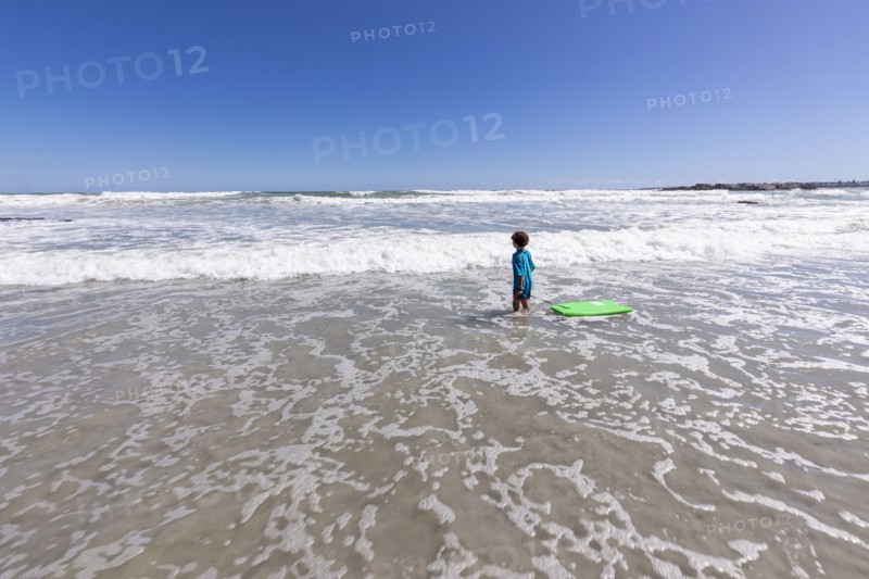 Boy with surfboard on beach
