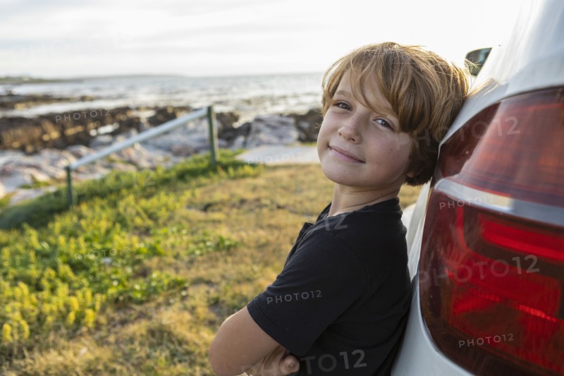 Portrait of Boy leaning on SUV