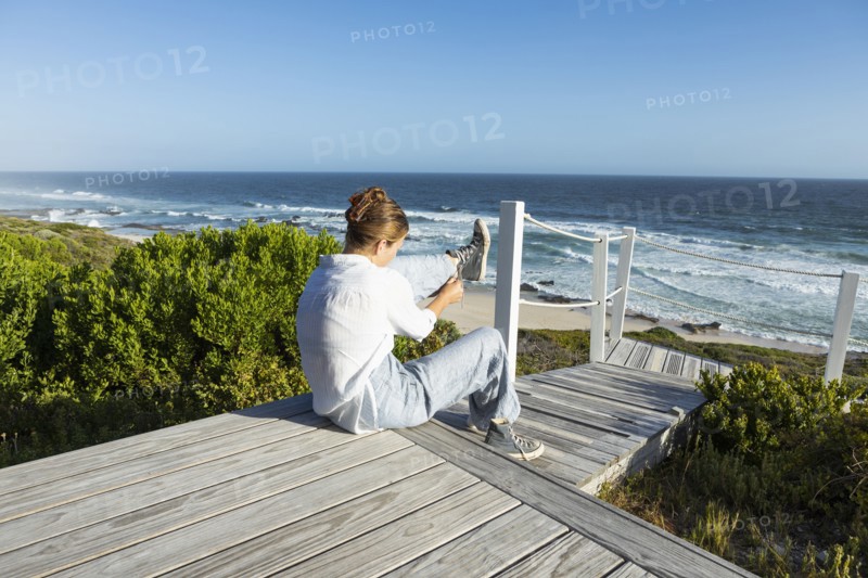 Girl sitting on boardwalk