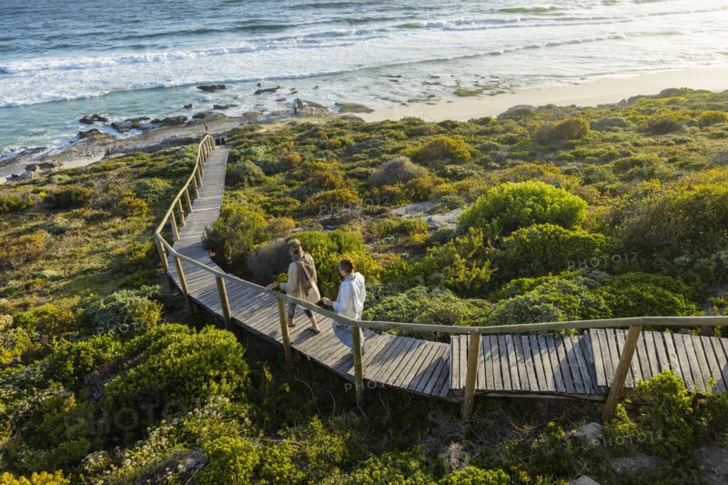 Mother and daughter walking on wooden bridge