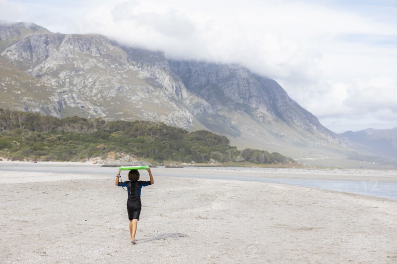 Boy carrying bodyboard on beach