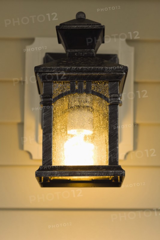 Electric lamp hanging on porch