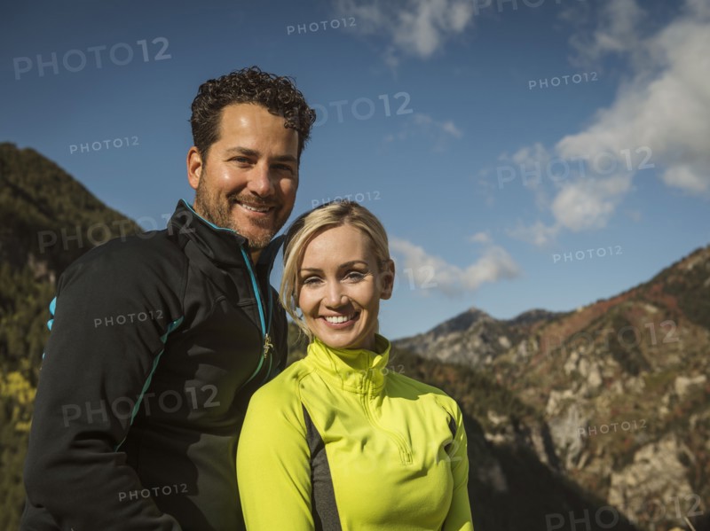 Portrait of smiling couple in mountain landscape