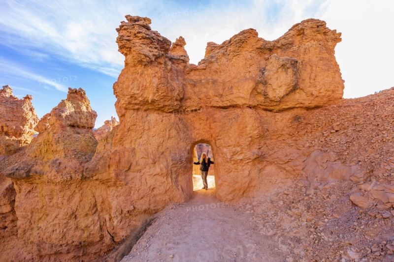 Senior hiker standing in sandstone archway