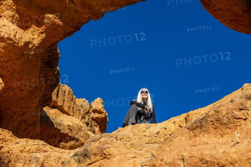 Senior hiker sitting on sandstone ledge