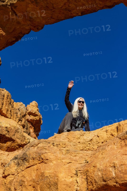 Senior hiker sitting on sandstone ledge