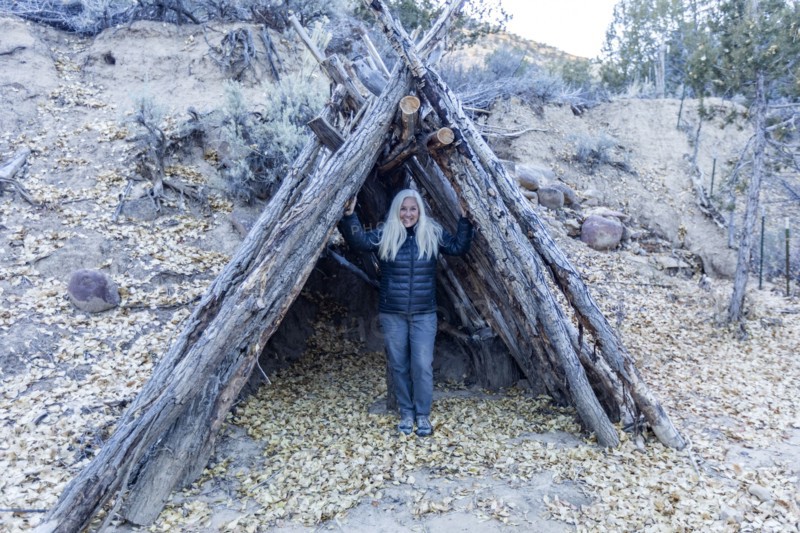 Senior female hiker standing in log shelter structure