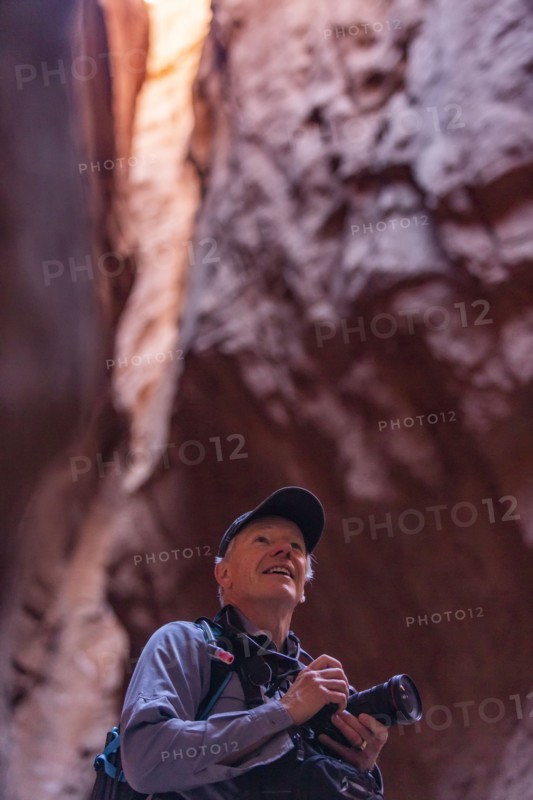 Senior male hiker with camera in canyon