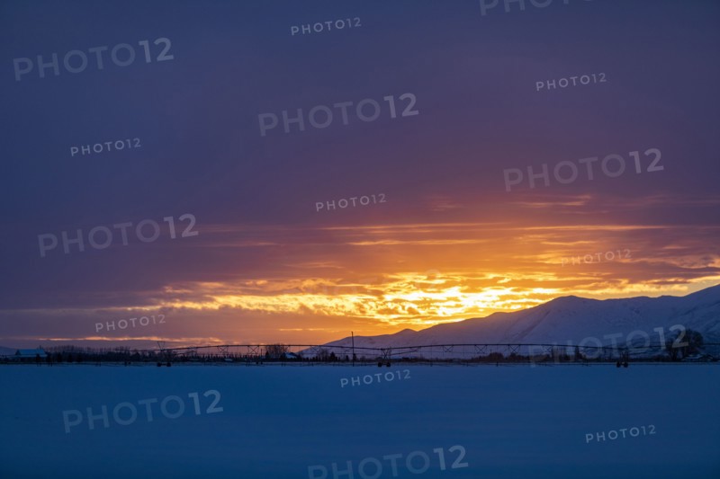 Sun rising above snowcapped mountains