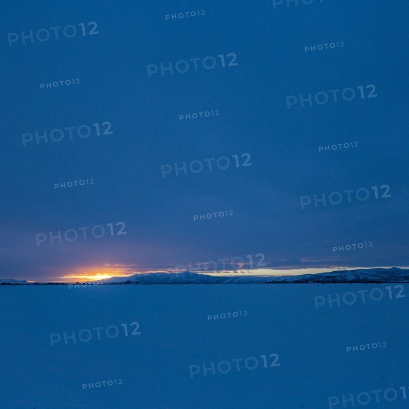 Sun rising above snowcapped mountains