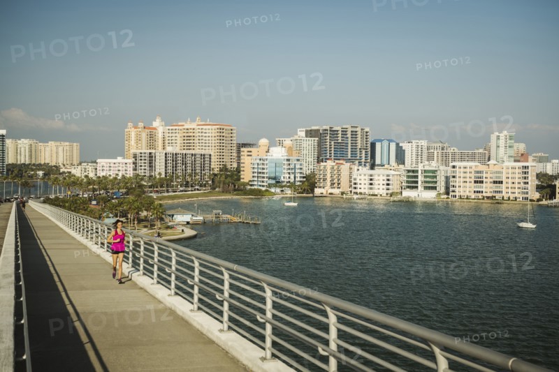 Woman jogging on bridge on sunny day