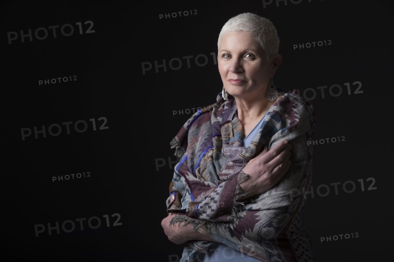 Studio portrait of woman with white short hair wrapped in shawl