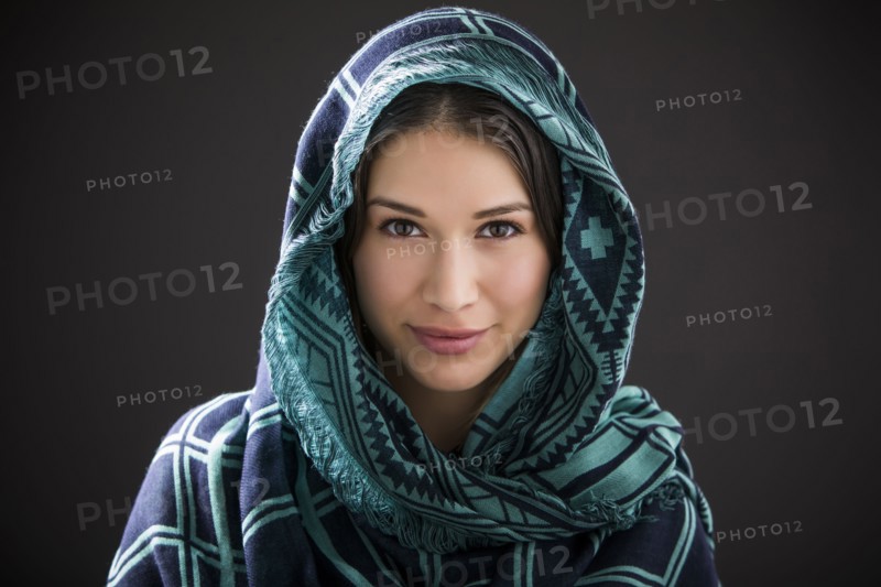 Studio portrait of smiling woman with shawl on head