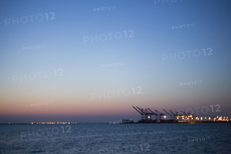 Silhouette of cranes in dock at dusk