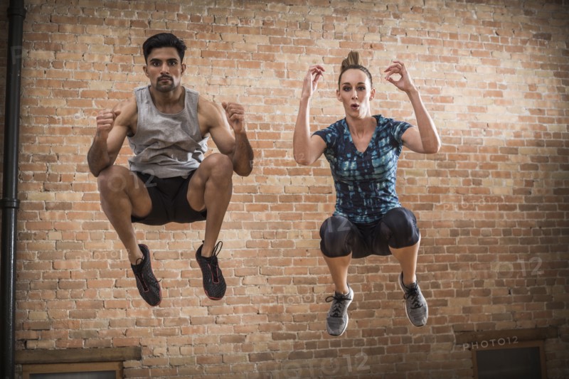 Man and woman jumping in gym