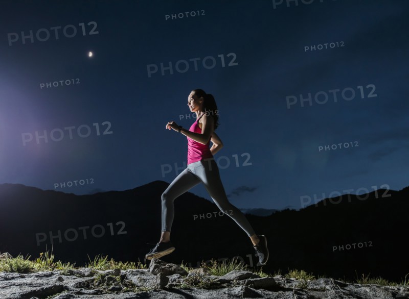Woman jogging in mountains at night