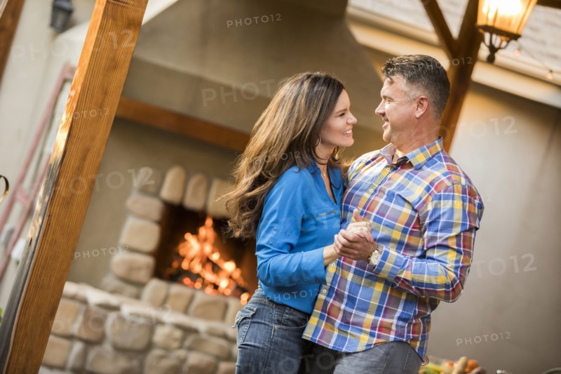 Mature couple dancing by fireplace