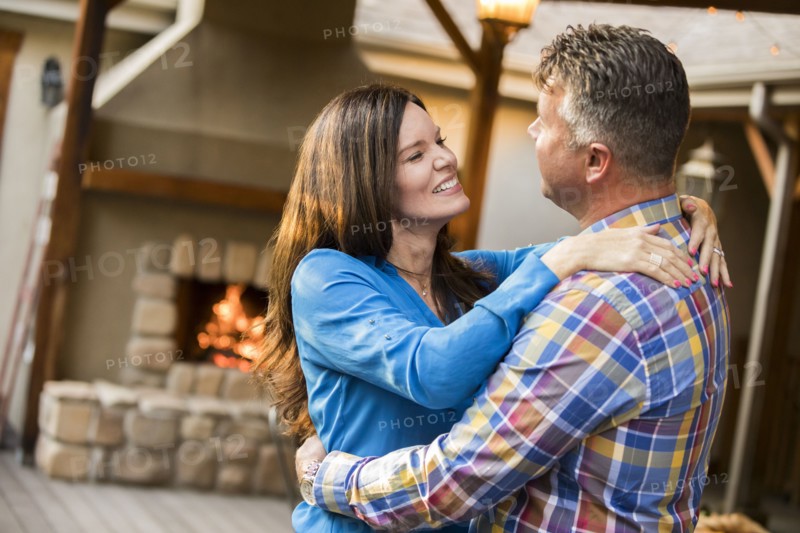 Mature couple dancing by fireplace