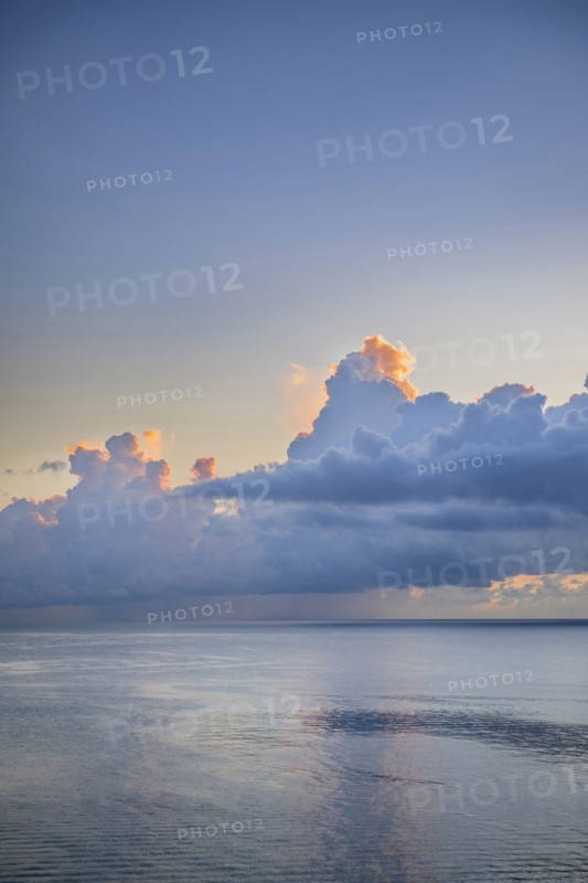 Large cumulus clouds over an early morning ocean
