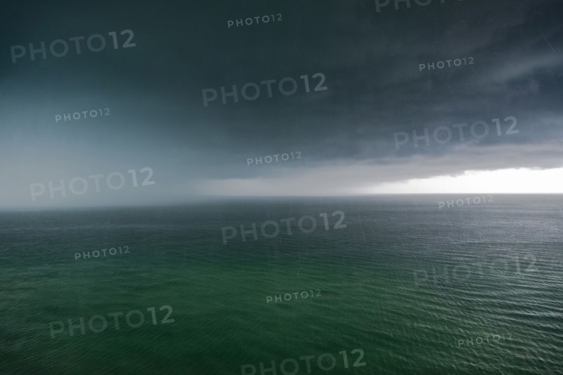 Thunder storm clouds and rain over ocean