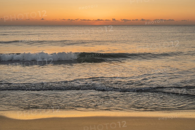Ocean waves on beach at sunrise