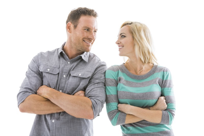 Studio shot of smiling couple with arms crossed