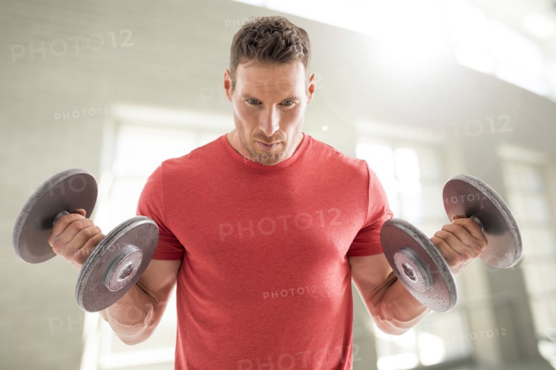 Man exercising with dumbbells in gym