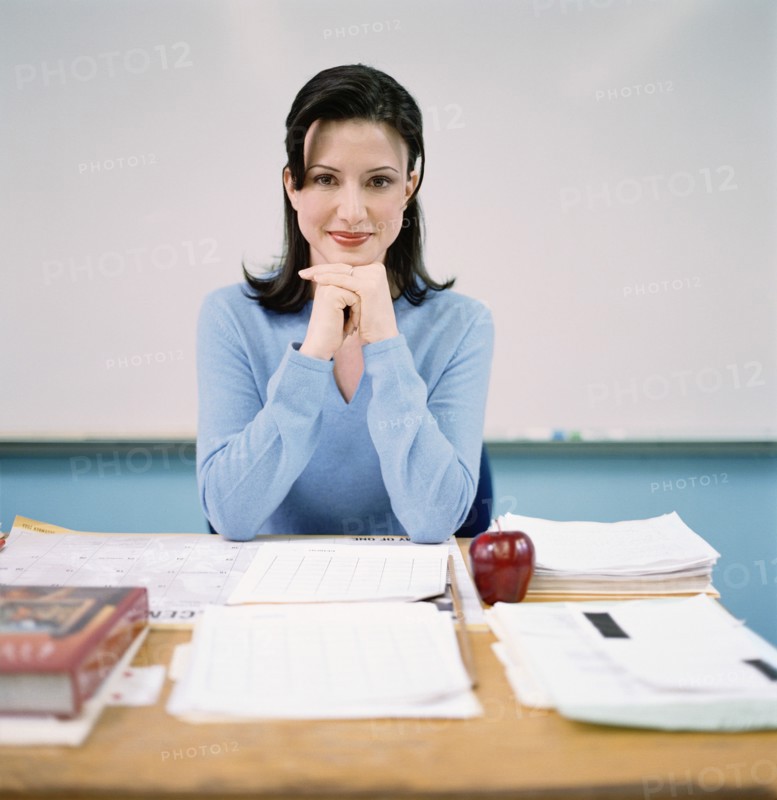Portrait of teacher sitting behind desk