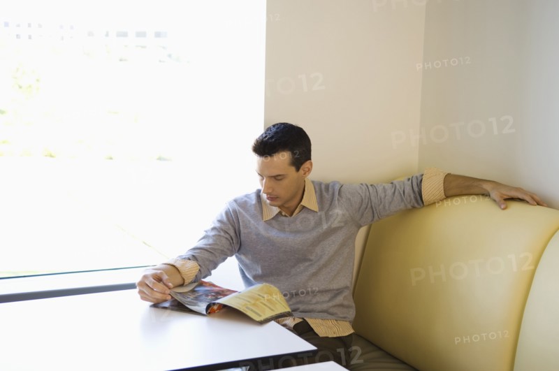 Businessman reading magazine in cafeteria