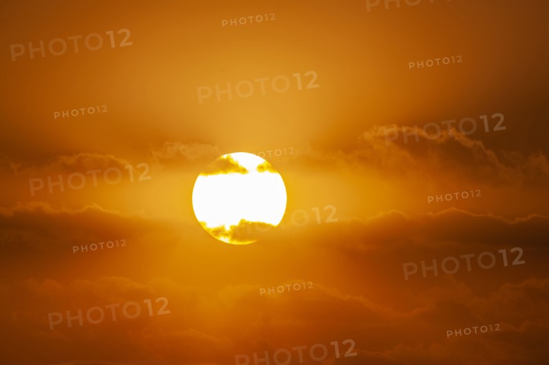 Sun with orange clouds in sunset sky