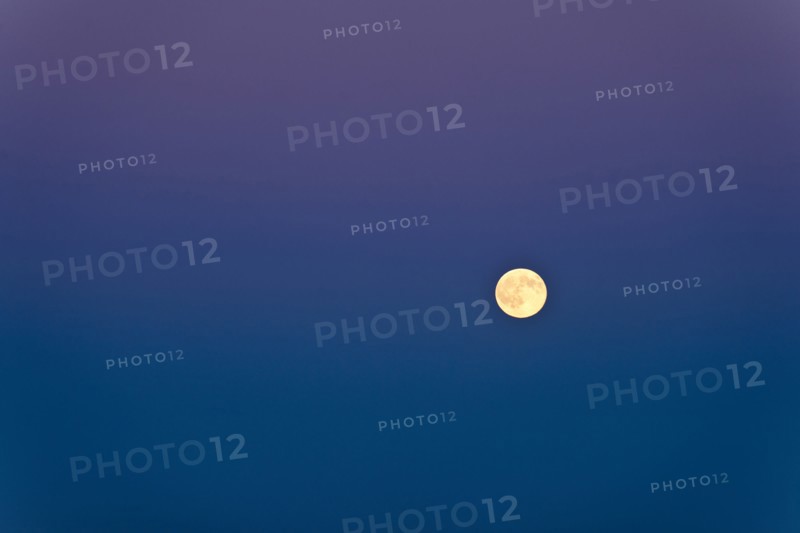Full moon against blue sky