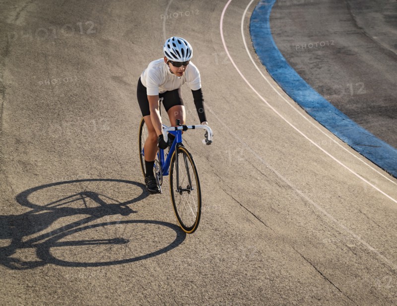 Athletic woman with amputated hand cycling on track