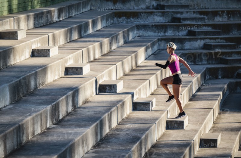 Athletic woman with amputated hand running up steps
