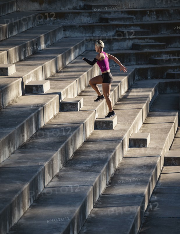 Athletic woman with amputated hand running up steps