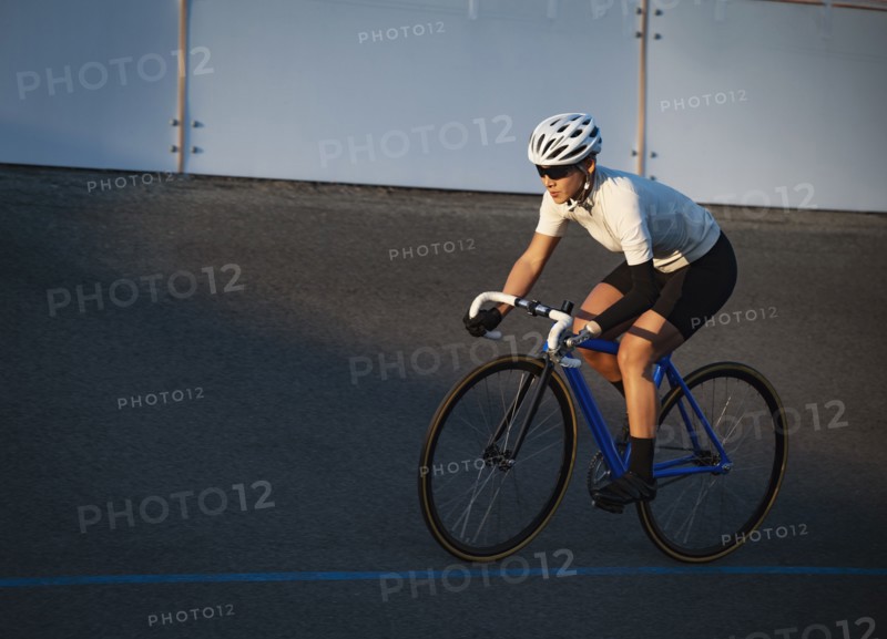 Athletic woman with prosthetic arm riding bicycle