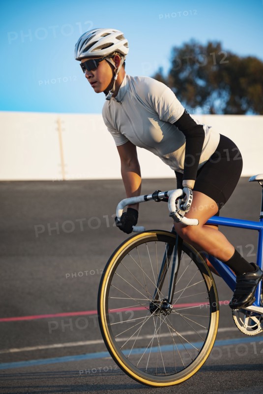 Athletic woman with prosthetic arm riding bicycle