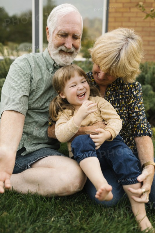 Smiling grandparents with granddaughter