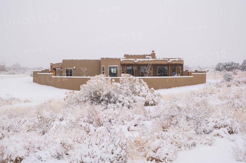 Pueblo style house in snow covered landscape