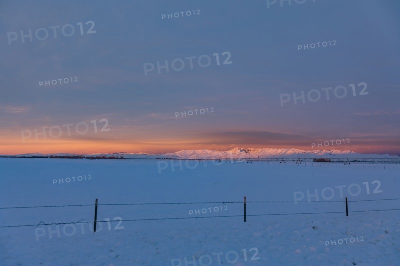 USA, Idaho, Bellevue, Snow covered field with hills in distance at sunrise